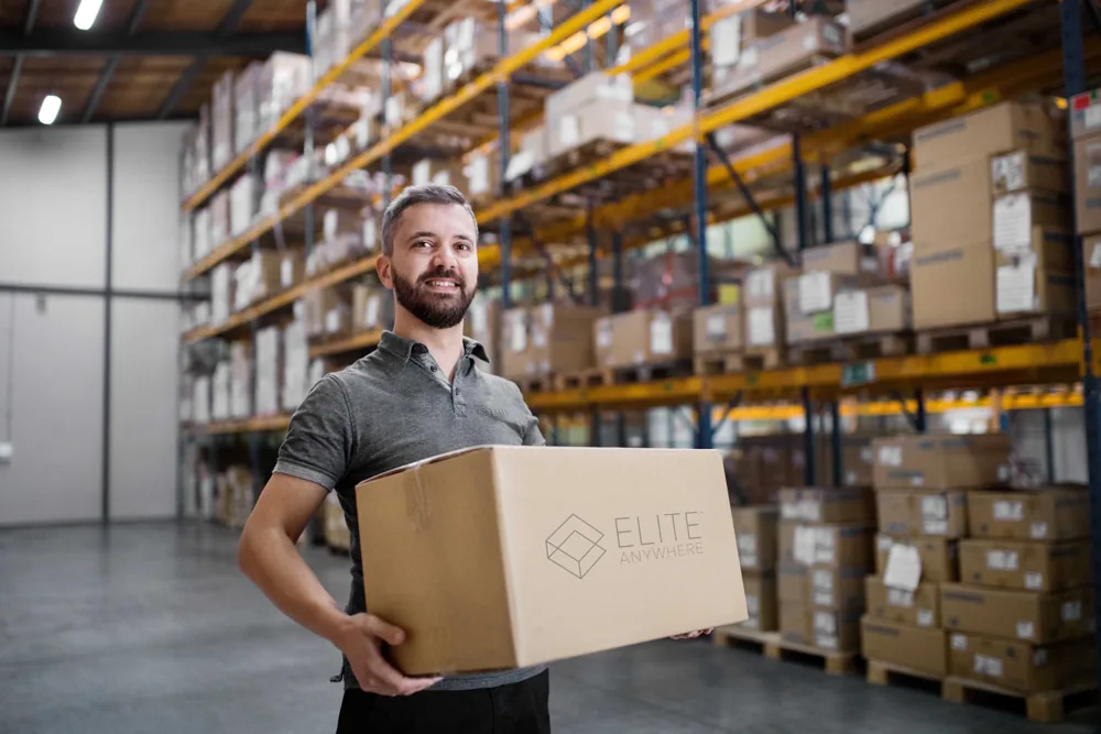 Elite Anywhere warehouse team member with a branded box